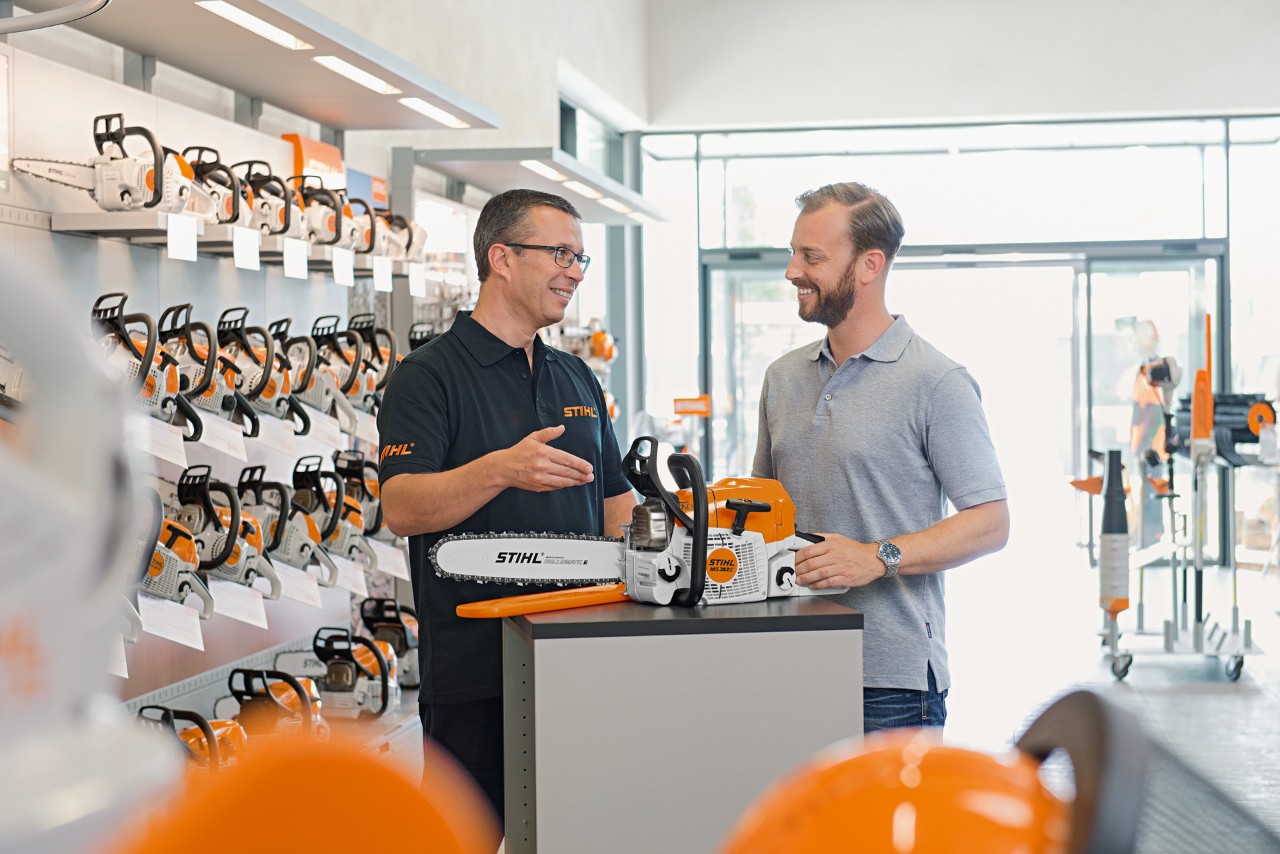 Дилер STIHL консультує чоловіка щодо купівлі ланцюгової пили STIHL