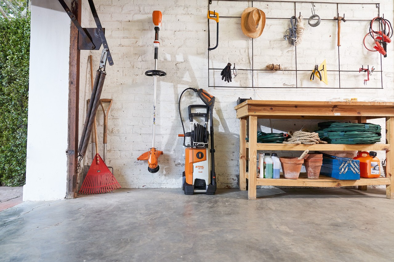 Мийка високого тиску STIHL RE 130 plus і мотокоса STIHL зберігаються в гаражі поруч із садовими інструментами