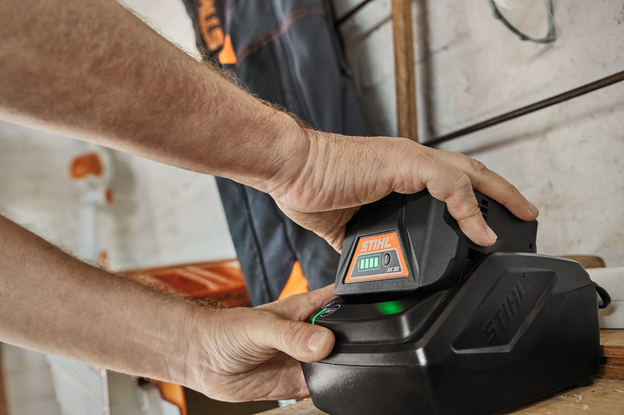 Літій-іонний акумулятор STIHL AK 30 заряджається в зарядній станції.