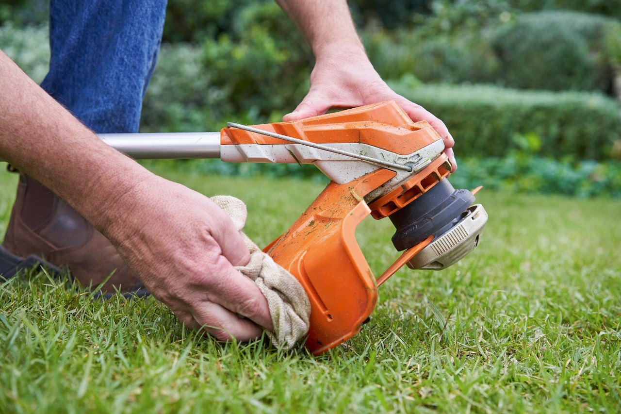 Захисний кожух мотокоси STIHL очищає людина за допомогою вологої ганчірки