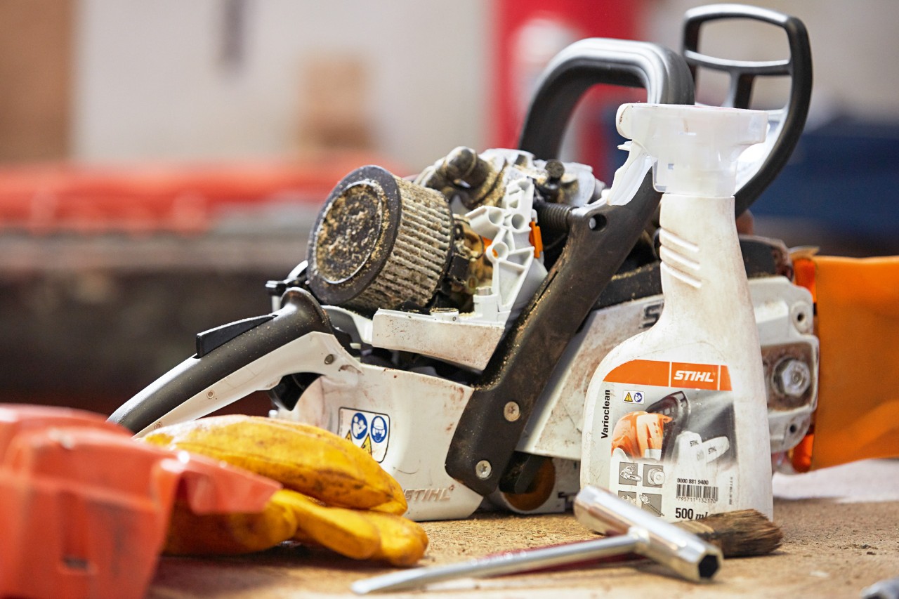 Очищувач STIHL Varioclean біля ланцюгової пили STIHL на робочому столі.
