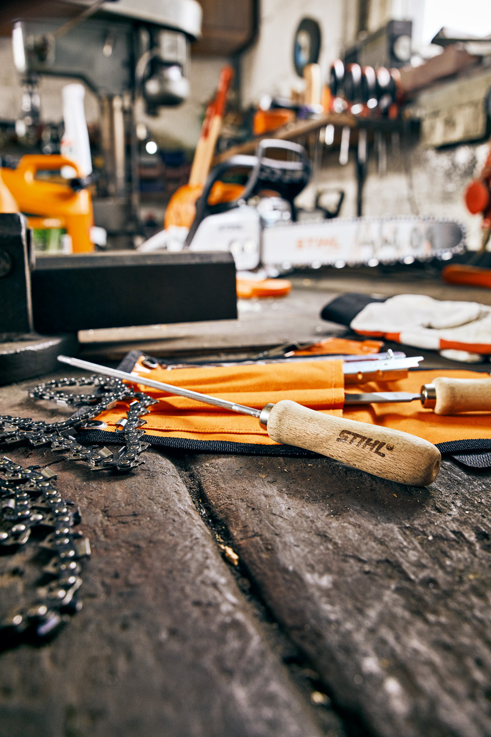 Напилки для ланцюгових пил STIHL та пиляльні ланцюги на робочому столі в майстерні.