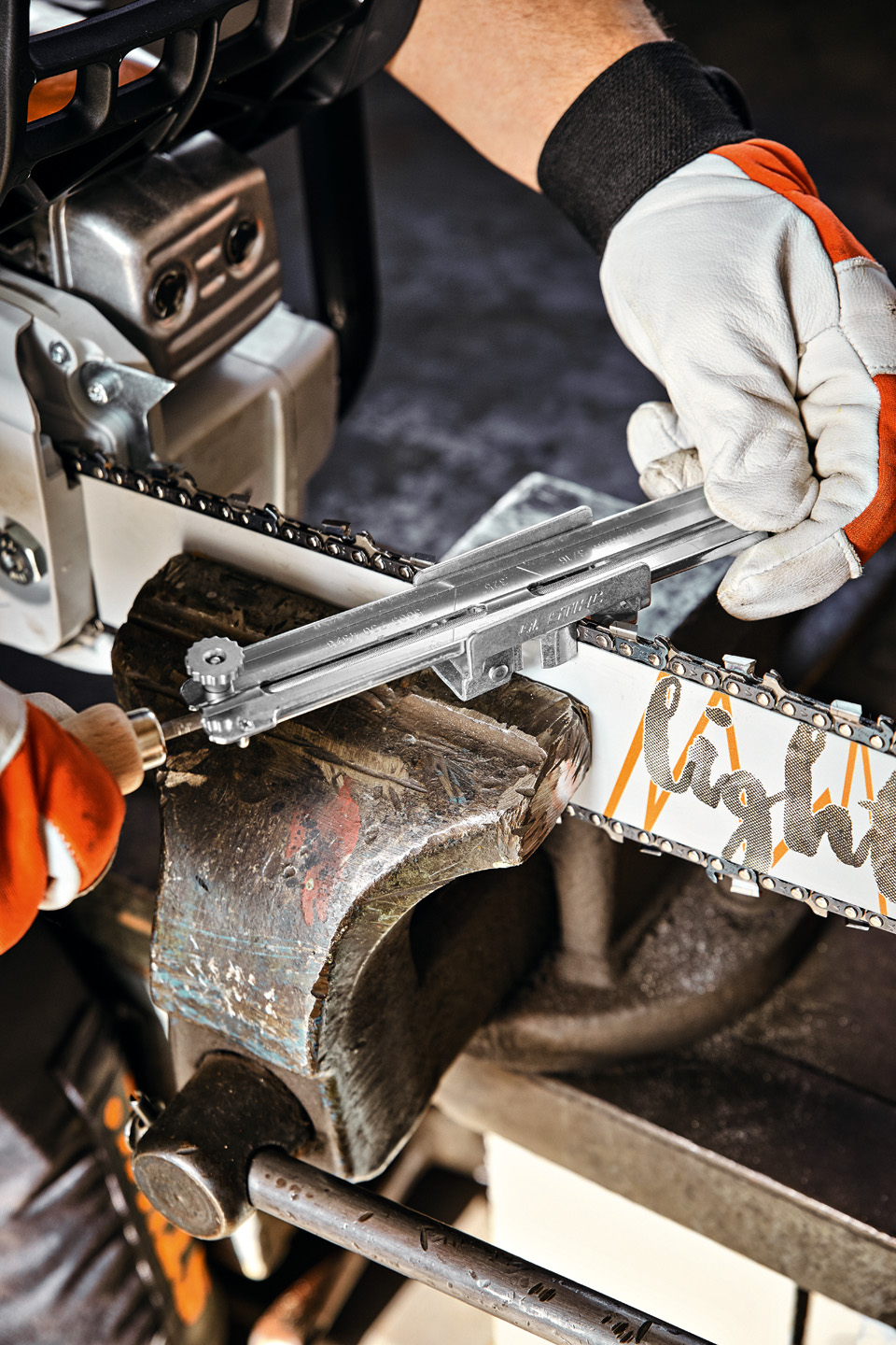 Людина з направляючою для тримача напилка STIHL на направляючій шині STIHL Light 04