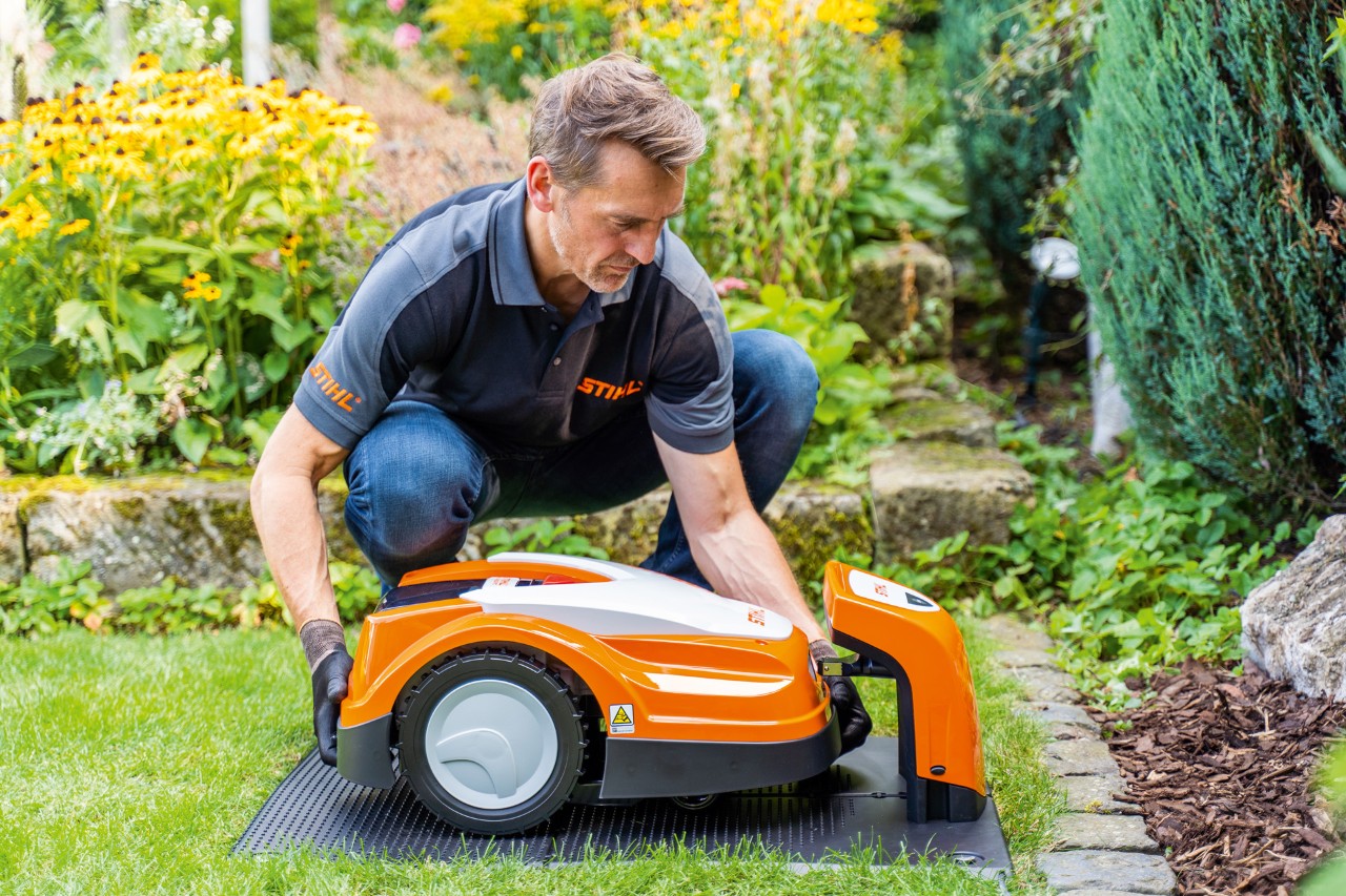 Дилер STIHL розміщує робот-газонокосарку STIHL iMOW на своїй зарядній станції в саду