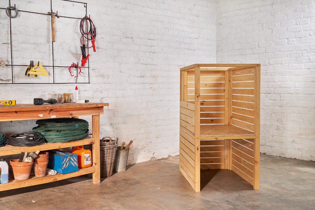 Das Grundgerüst einer selber gebauten Rasenmäher-Aufbewahrung in einer Garage 