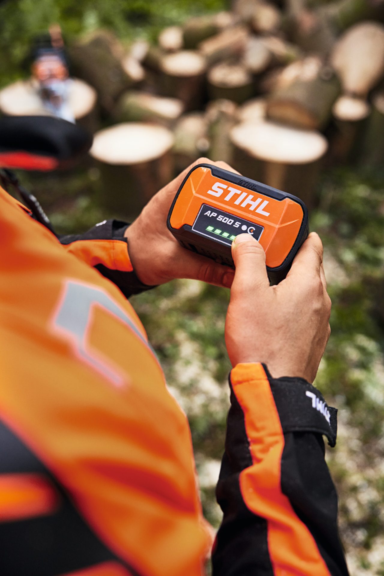 Крупним планом людина тримає в руках літій-іонний акумулятор STIHL AP 500 S