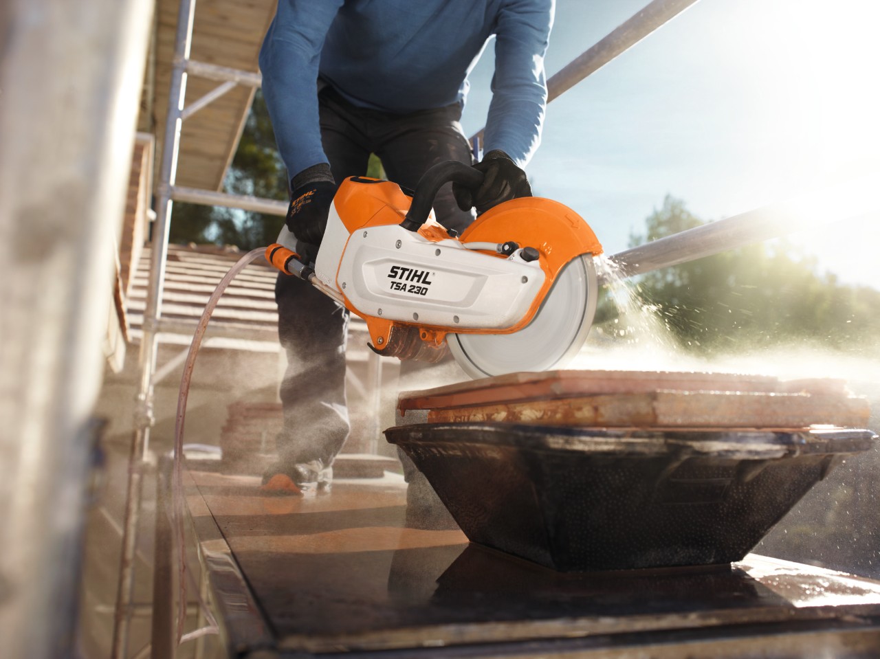 Людина на риштуванні працює ручним акумуляторним моторізом STIHL TSA 230