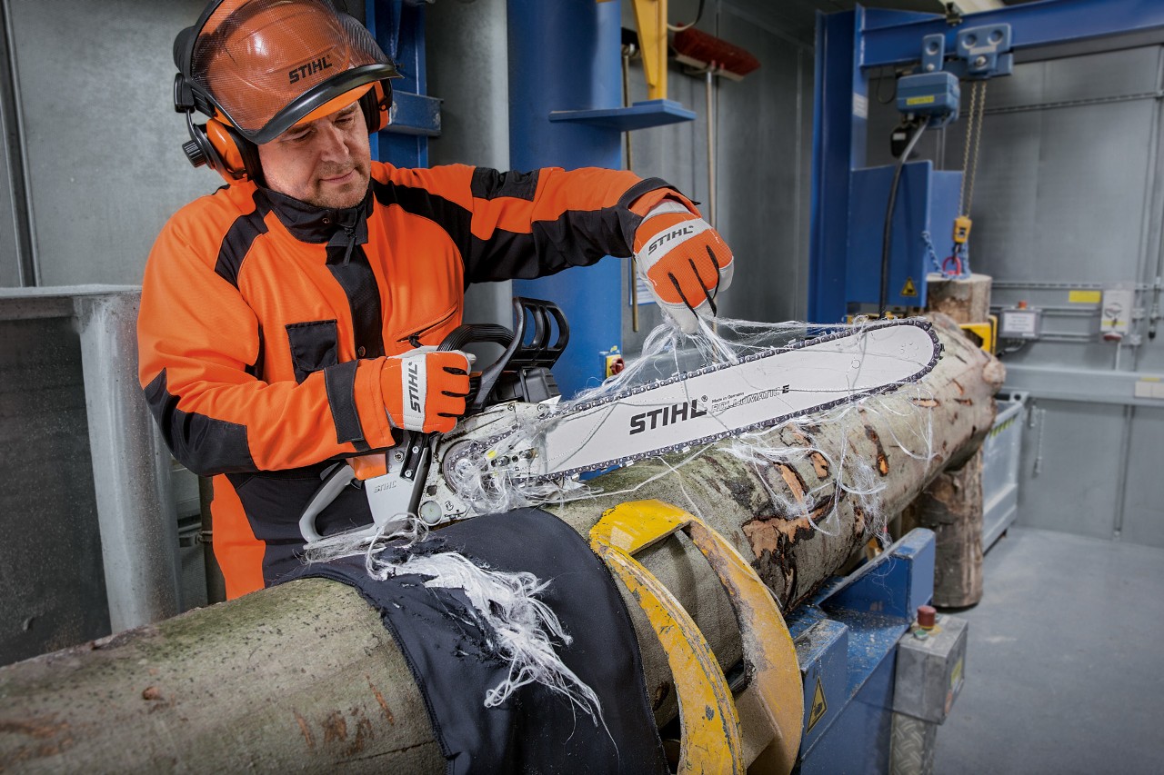 Person in Schutzkleidung testet den Schnittschutz der STIHL Schutzkleidung mit einer STIHL Kettensäge